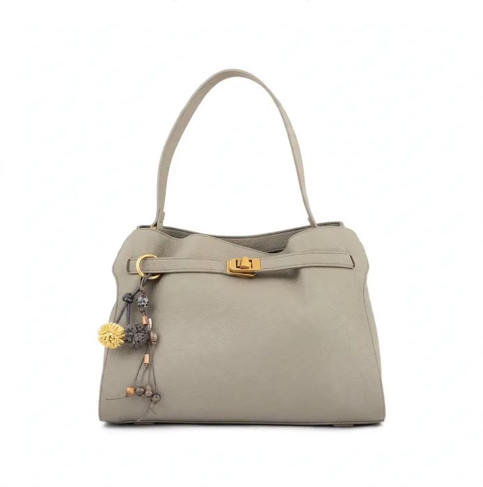 Front view of taupe grey pebbled leather shoulder bag with gold buckle and yellow grey pom-pom tassel charms on white background