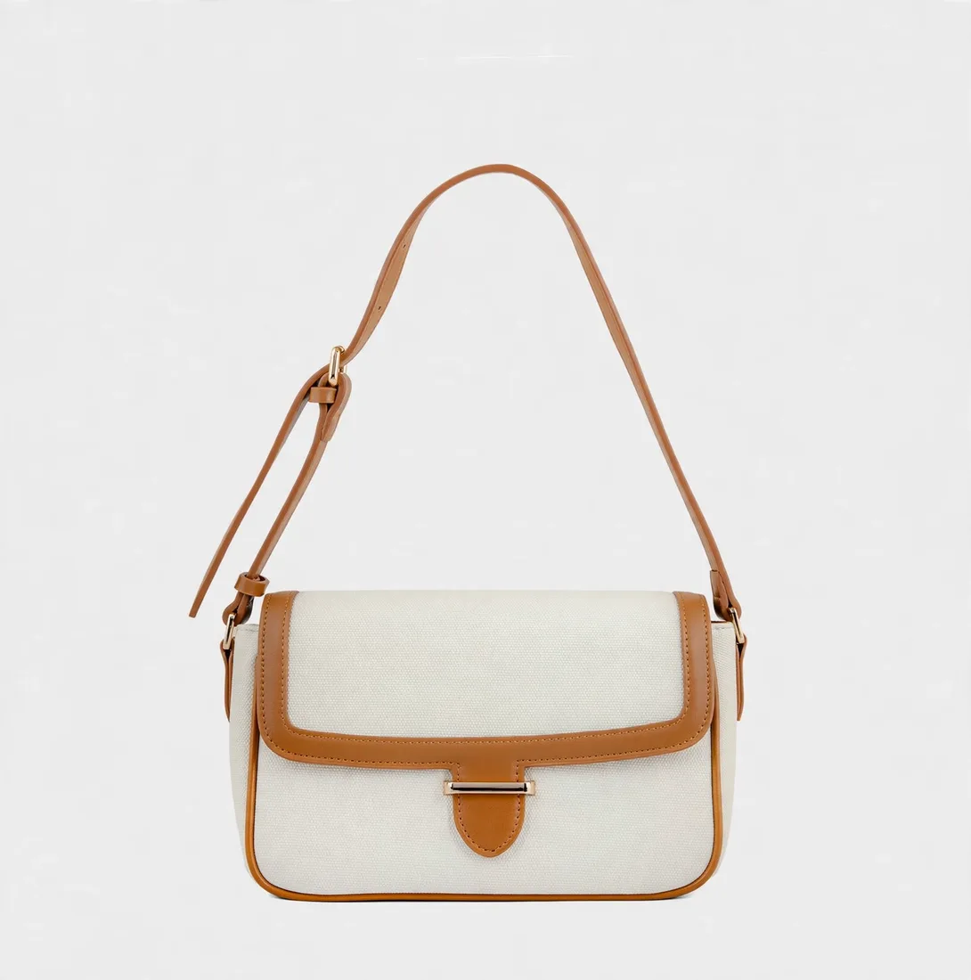 Front view of off-white canvas flap shoulder bag with tan brown faux leather
